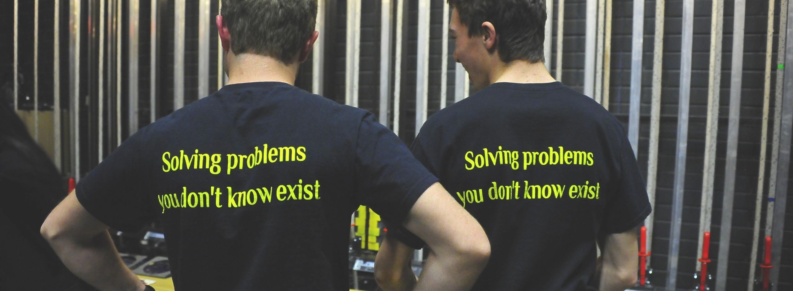 Two young people in Solving Problems you don't know exist t-shirts